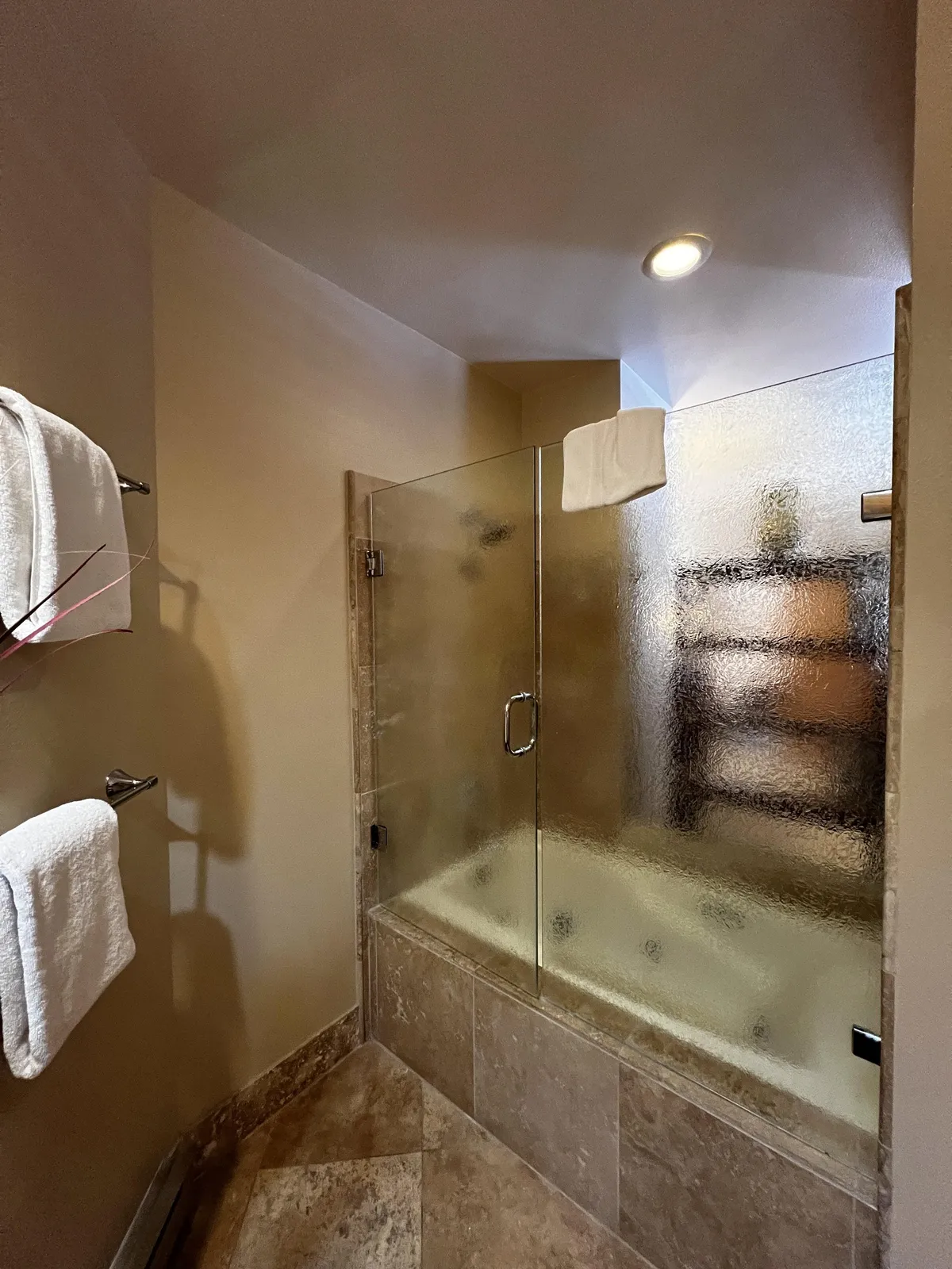 A spa-inspired bathroom with a glass-door shower, an inviting tub, and neatly arranged towels. The space is bright and serene, suggesting a luxurious escape for relaxation and rejuvenation after a long day in the mountains.